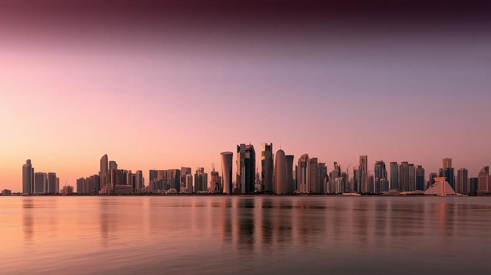 A wide view across the bay towards a city skyline at first light